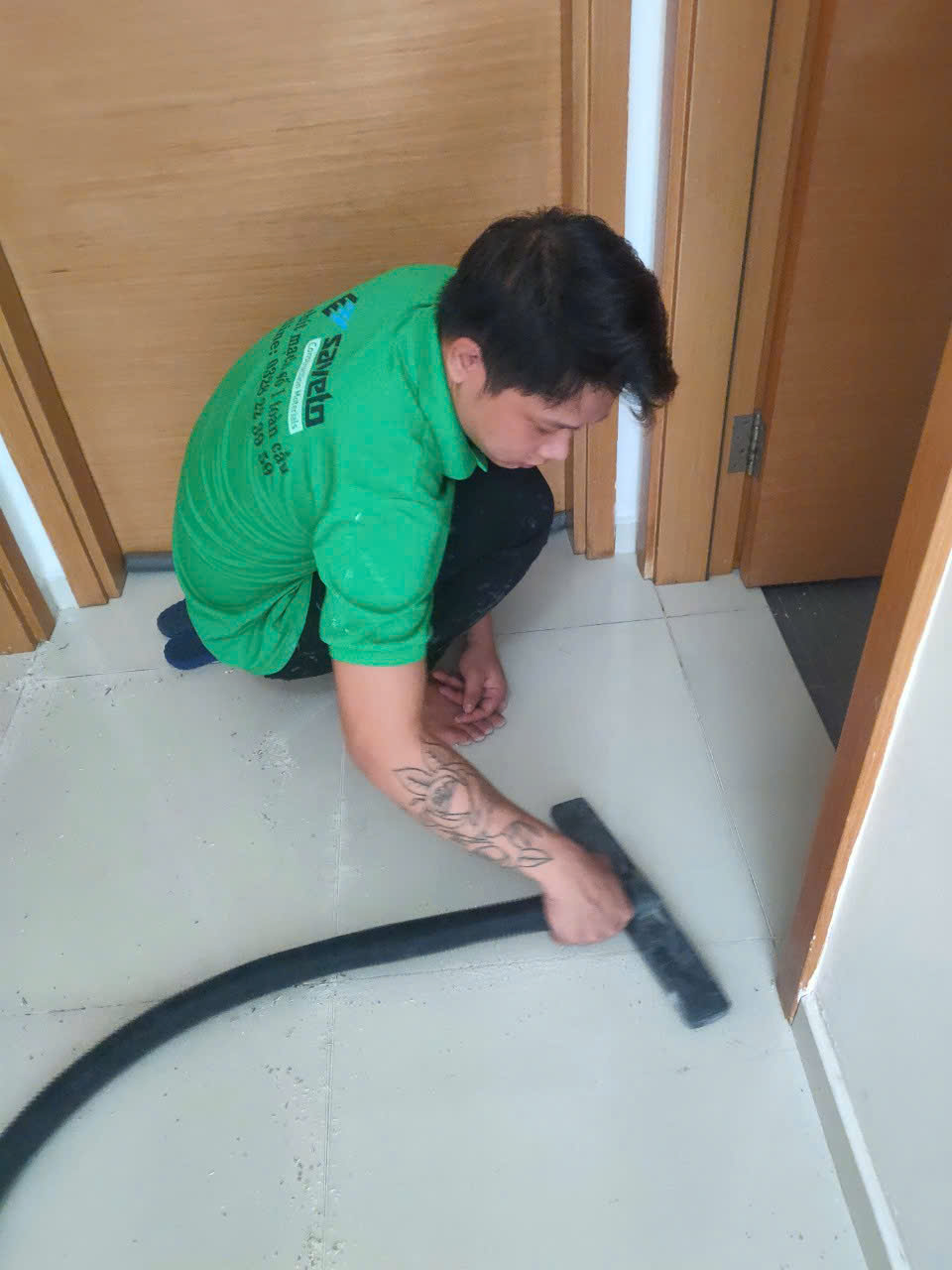 Thợ dùng máy hút bụi vệ sinh khe ron trước khi thi công