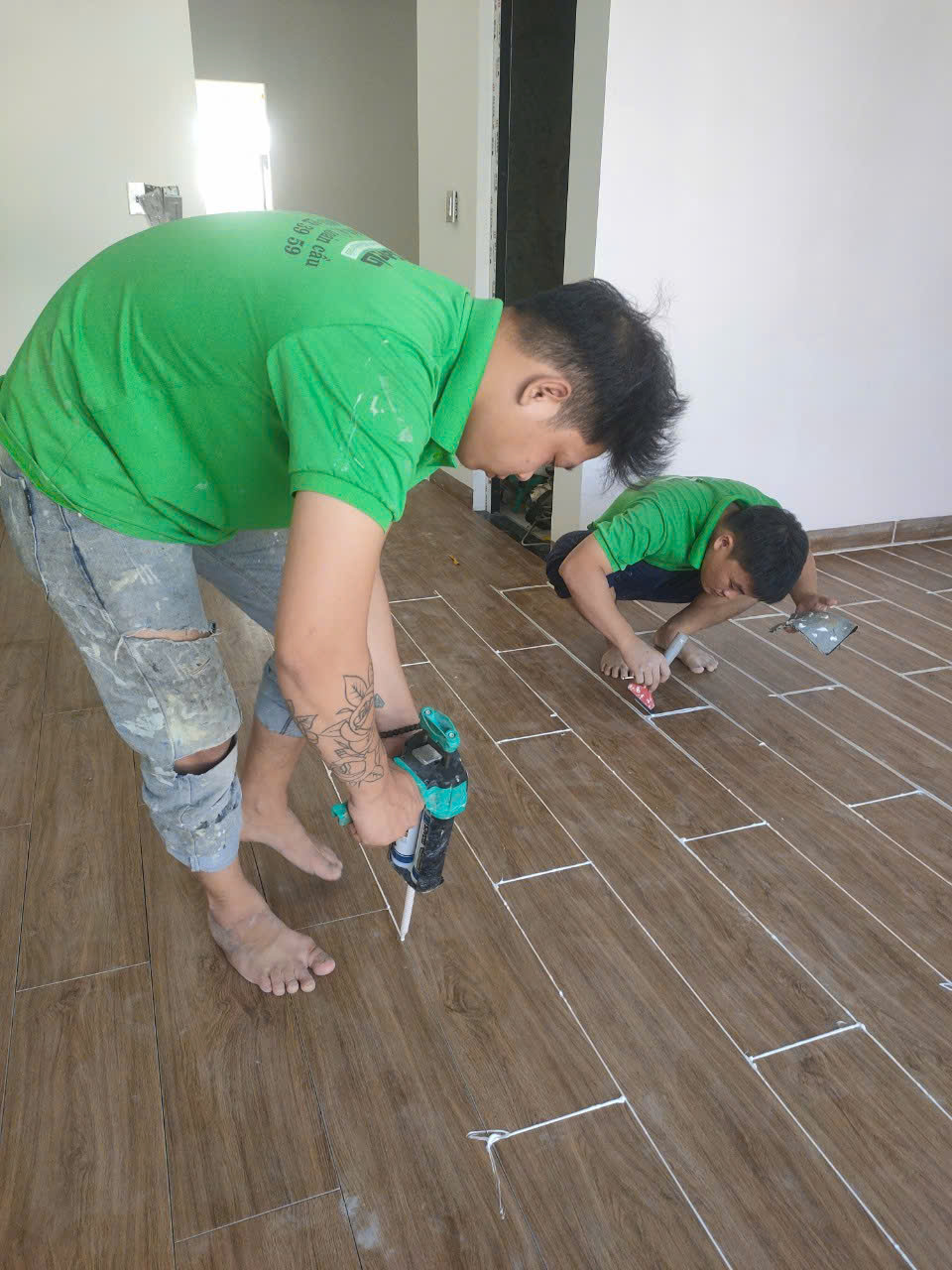 Đội thợ 2 người thi công keo ron sàn gỗ