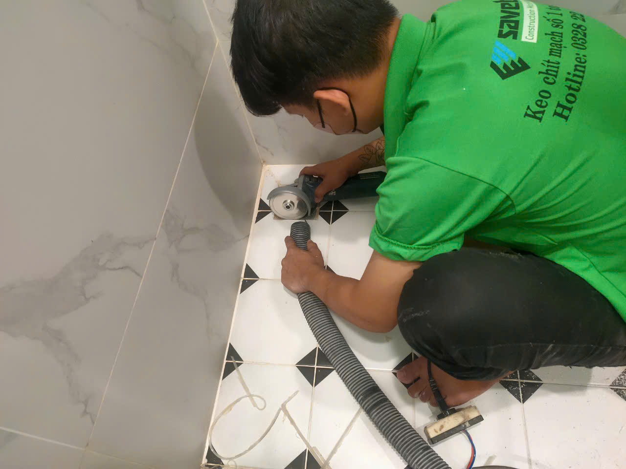 Thợ dùng máy mài xử lý ron cũ trước khi thi công mới