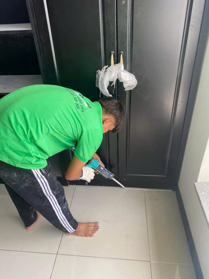 Thợ đang bơm keo silicon vào khe ron góc tường